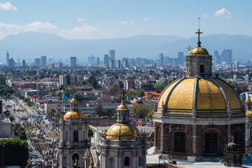 Historical landmark Basilica of Our Lady of Guadalupe and Mexico City skyline on a sunny day.