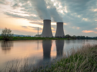 Nuclear power plant against sky by the river at sunset