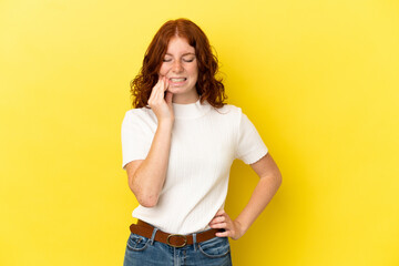 Teenager reddish woman isolated on yellow background with toothache