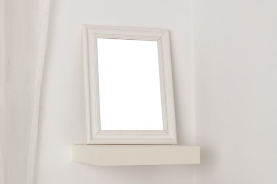 empty photo frame with a place to copy on a white shelf at home