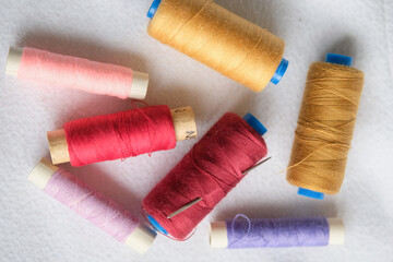 wooden reels with thread on a solid background.