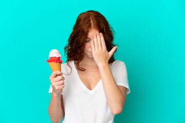 Teenager reddish woman with a cornet ice cream isolated on blue background with tired and sick expression