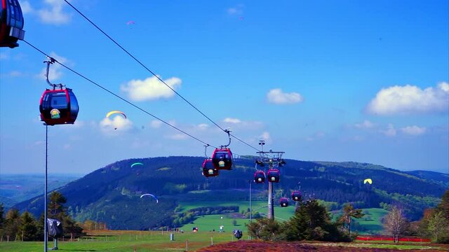 A cabin cable car travels up a mountain in summer - video clip