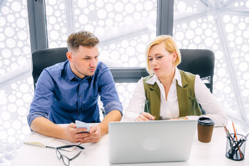 Confident female manager training the male intern trainee. Team leader supervisor mentor teaching...