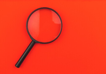 Magnifying glass on a red background isolated, top view photo