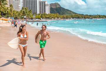 Hawaii surf lifestyle couple of surfers going surfing in Waikiki beach, Honolulu, Oahu island. USA...
