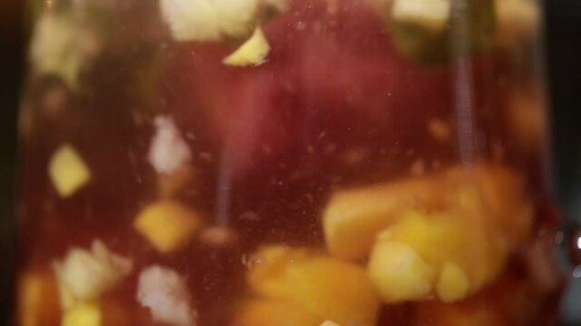 the process of brewing fruit tea in a glass teapot close-up.