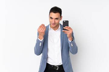 Young handsome businessman on isolated background making money gesture