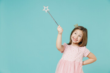 Little fun kid girl princess 5-6 years old wears pink dress crown diadem hold magic wand fairy stick isolated on pastel blue color background child studio. Mother's Day love family lifestyle concept. - obrazy, fototapety, plakaty