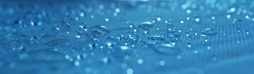 Clear water drops on a blue background. Close-up