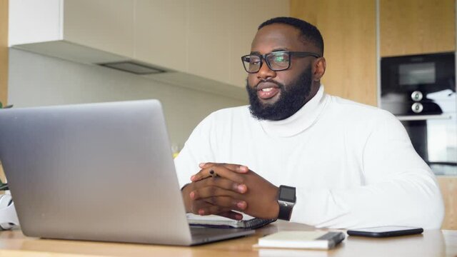 Smiling young african businessman teacher conference calling by laptop webcam
