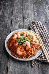 Stir fry noodles with shrimps and vegetables on wooden table