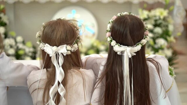 First Holy Communion. Elegant girls with bows on their heads.
