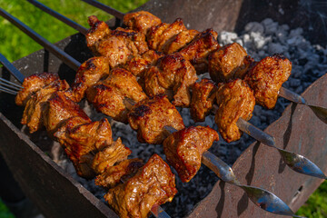 Grilled meat on skewers, fried kebabs on skewers on rusty brazier
