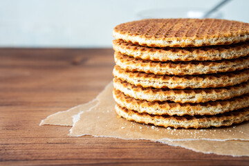 Traditional local authentic Dutch Netherlands sweet fresh homemade tasty stack brown golden waffle melt salted caramel honey syrup for dessert in cafe with hot warm coffee milk tea call Stroopwafel