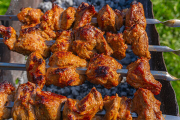 Grilled meat on skewers, fried kebabs on skewers on rusty brazier