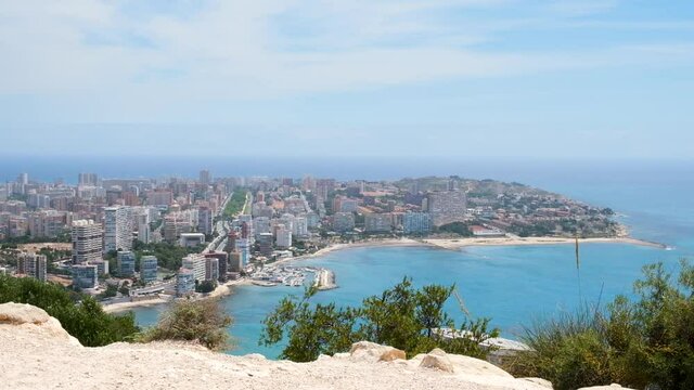 View over Alicante town from Serra Grossa mountain. Cabo de la Huerta district with its beaches and rugged shoreline of the Mediterranean sea. Costa Blanca region in Spain