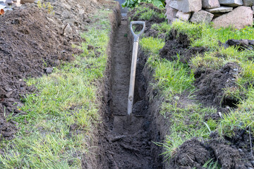 Drainage ditch out of house made by shovel.