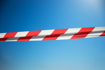 Red and White Lines of barrier tape on a blue  background. Do not cross, closed passage, ban,...