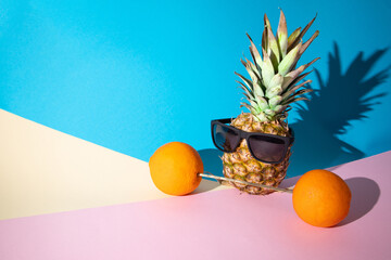 Pineappple with sunglasses and two oranges forming gym weights, fitness summer concept, modern...