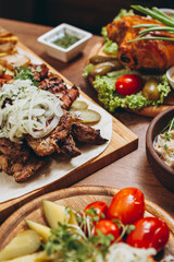 assorted various meat and vegetable dishes laid out on the village board for serving in a restaurant of Ukrainian cuisine