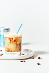 Iced cold brew coffee with coconut milk and mocha in glass with straw on white background with copy space. Menu mockup. Summer cold refreshing drink concept.