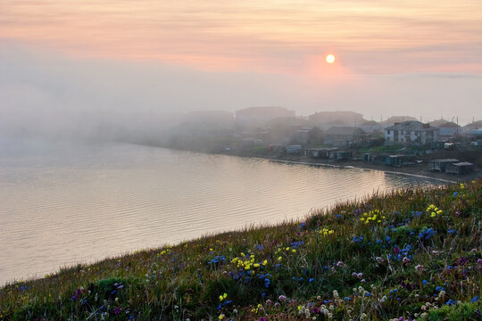 View of the coastal arctic settlement. The Chukotka village Uelen is the easternmost settlement of Russia and Eurasia. The village of Uelen on the coast of the Chukchi Sea of the Arctic Ocean. Fog.