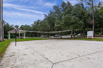 Fototapeta na wymiar Beach volleyball court in a park surrounded by trees