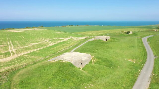 Une route longe les quatre casemates de la batterie de Longues-sur-Mer en France, en Normandie, dans le Calvados, au bord de la Manche, au printemps.