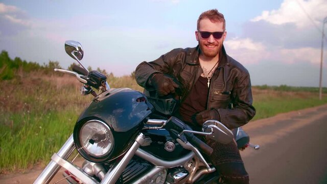 Portrait of a biker on a motorcycle chopper with sun glasses