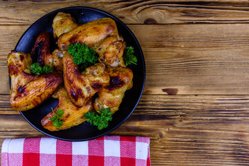 Pile of the roasted chicken wings on plate. Top view