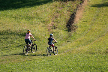 Fototapeta premium Two girls on mtb bikes. Mother and daughter riding on a trail.