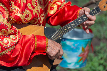A man plays the balalaika (musical instrument).