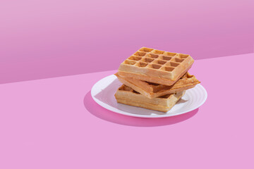 Waffles stack isolated on pink pastel background. Copy space