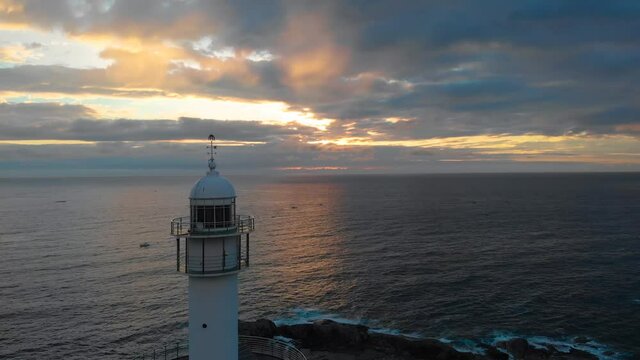 Lighthouse at sunrise of east coast sea of Korea. Sun is gold and clouds are turning golden. Beautiful nature and landmark aerial drone footage took with 4K 30fps.