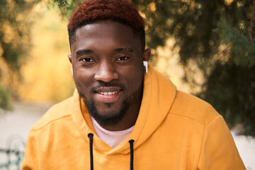 Multiracial man wearing earphones looking at the camera with pleasure smile