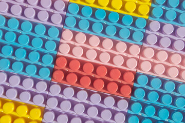 children's play background: the plane of plastic multi-colored bricks, blur, selective focus