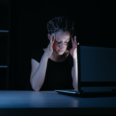 Tired exhausted woman working with laptop at night