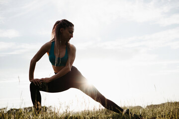 Sporty woman doing stretching exercises in nature