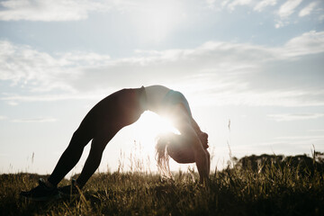 Sporty fit young woman doing yoga in nature