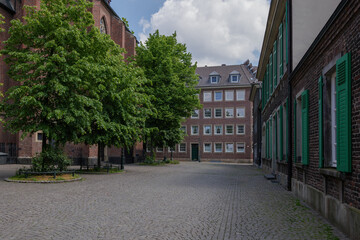 Fototapeta na wymiar Outdoor sunny and shady tranquil view around Stiftsplatz and St. Lambertus Church in old town Düsseldorf, Germany without people. 