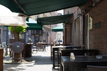 Selective focus at outdoor table and chair without people in front of cafe, bar, and restaurant in walking street old town D&uuml;sseldorf, Germany.