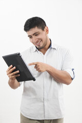hombre latino sonriente revisa su tableta con actitud alegre