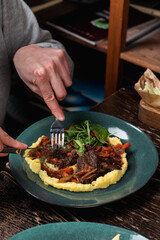 Eating comfort food in a restaurant: boeuf bourguignon with potato, top view