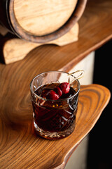 Posh cherry cocktail with rum in an old fashioned style glass, reflection on a bar counter