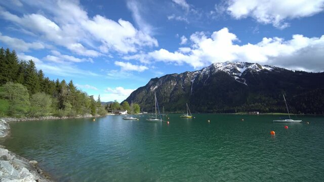 Boats and yachts on Achen lake in Tyrol. Water surrounded by high mountains, somewhere between Innsbruck and Munich.