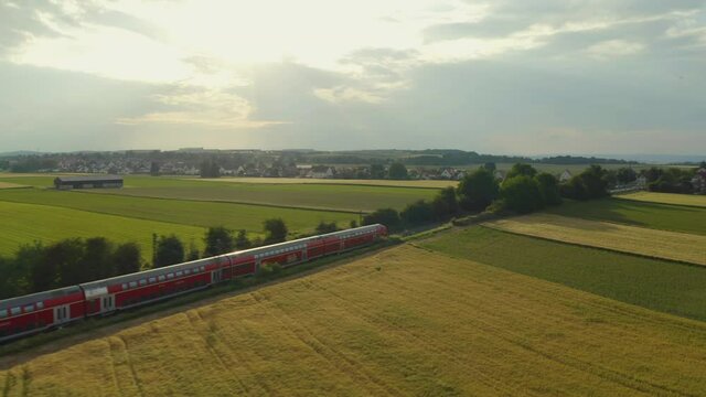 Aerial of a German train going through the countryside during sunset