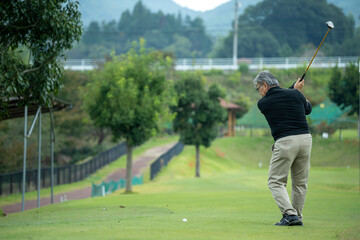 ゴルフを楽しむシニア男性