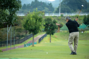 ゴルフを楽しむシニア男性