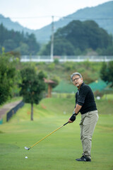 ゴルフを楽しむシニア男性